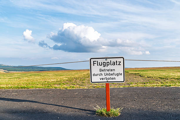 warning shield in German language saying: Airfield, Entry by unauthorized persons prohibited.
