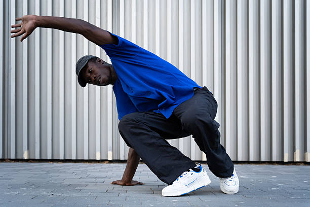 istock Young man breakdancing in an urban setting, showcasing impressive moves and agility against a vibrant city backdrop 2234019528