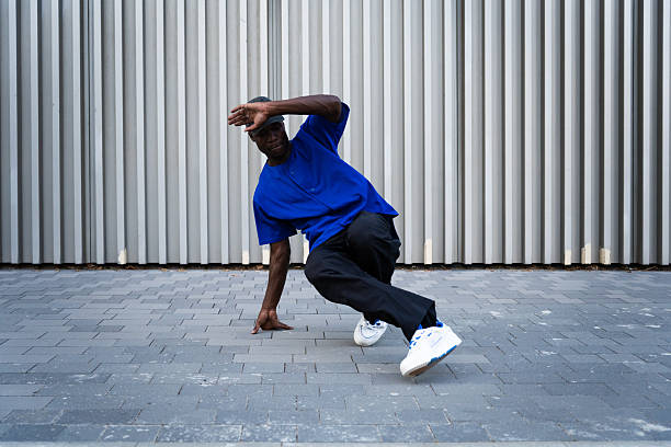 istock Street breakdancer performing dynamic freeze pose, showcasing urban style on concrete sidewalk with athletic movement and urban backdrop 2234019838