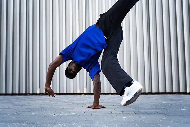 istock Breakdancing performer inverting body, displaying athletic prowess against colorful city background 2234019926