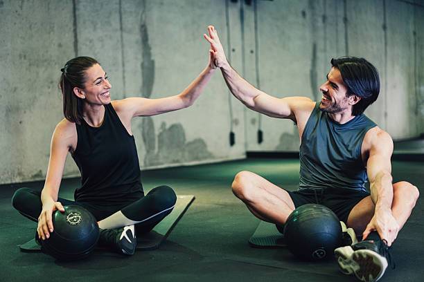 istock Couple giving each other high five after a successful workout in a gym. 2234024993
