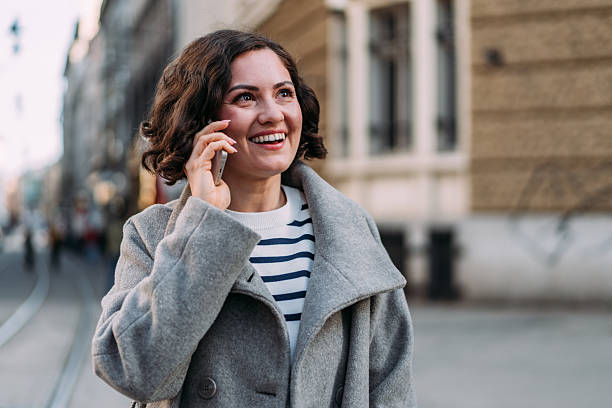 istock Cheerful woman using cell phone on the street. 2234025207