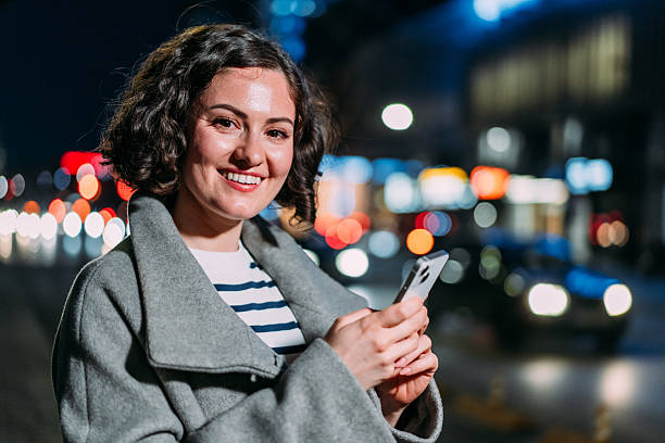 istock Cheerful woman using smart phone outdoors. 2234025210