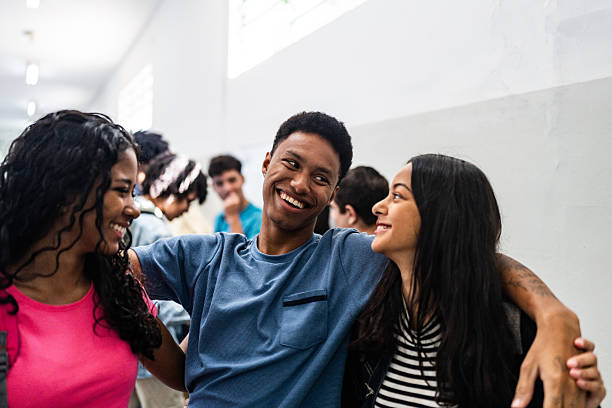 istock Smiling student friends embracing in the corridor at school 2234028529