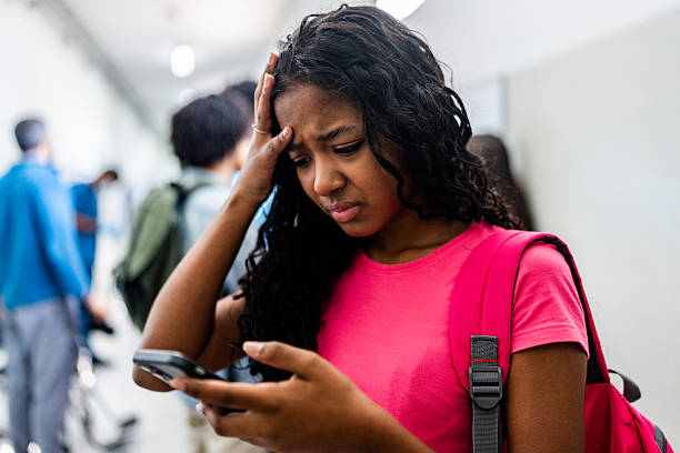 istock Teenager concerned while using mobile phone at school 2234028551