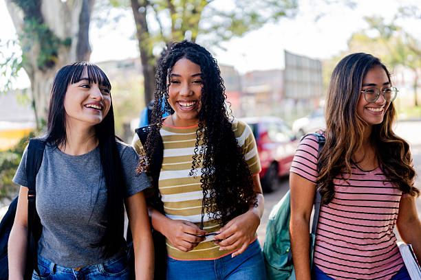 istock Smiling student friends talking and walking outside school 2234028798