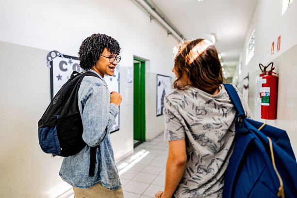 istock Student friends talking and walking around school hallways 2234032559