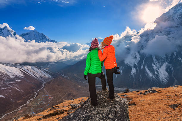 Two young women standing on the top of a mountain and watching sunset over Himalayas. Mount Everest National Park. This is the highest national park in the world, with the entire park located above 3,000 m ( 9,700 ft). This park includes three peaks higher than 8,000 m, including Mt Everest.