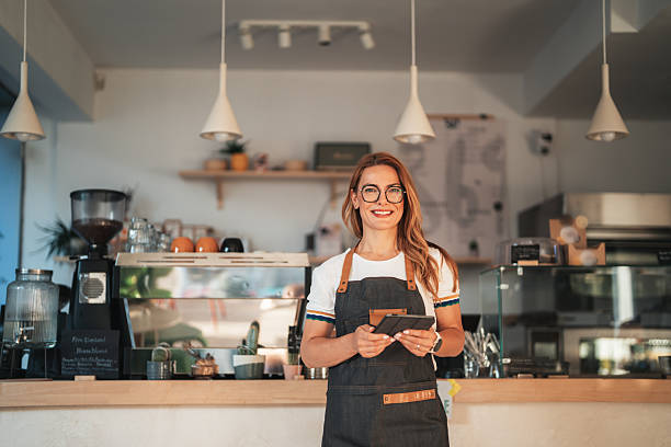istock Smiling beautiful waitress with tablet in modern coffee shop 2234043188