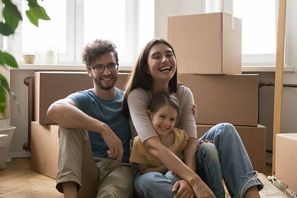 istock Overjoyed family spouses with kid cuddle on floor by boxes 2234044365