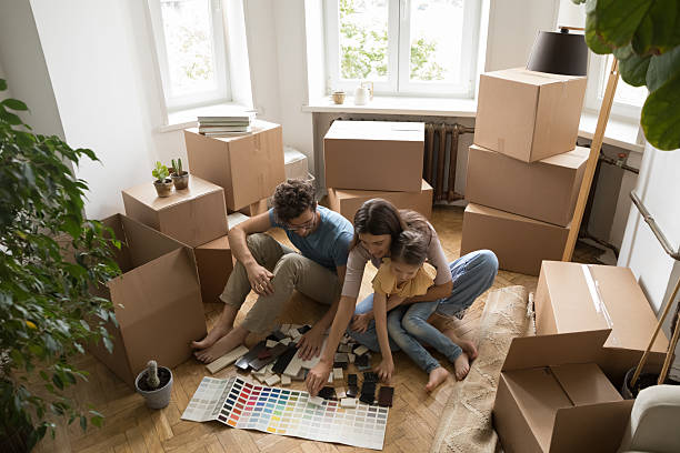 istock Parents with kid sitting on floor among boxes planning renovation 2234046578