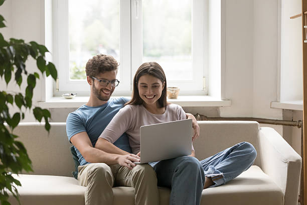 istock Happy young couple spend leisure time on couch with notebook 2234046912