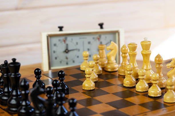 istock Chess pieces on a chessboard on the background of a chess clock. 2234049273