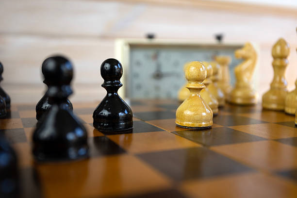 istock Chess pieces on a chessboard on the background of a chess clock. 2234049369