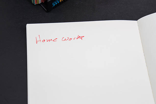 istock notebook with writing in it for homework with school supplies behind it 2234052586