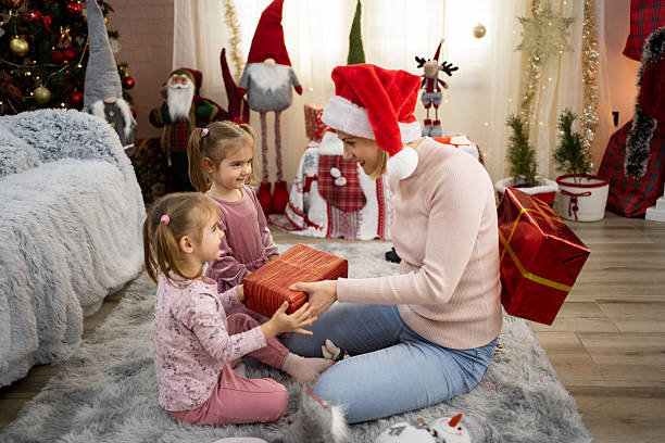istock Mother giving Christmas presents to her two daughters 2234052949