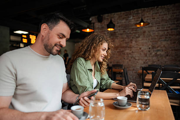 istock Young Couple Working on Devices and Drinking Coffee in Cafe 2234055961
