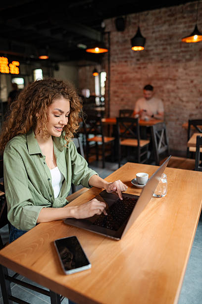 istock Young woman working on laptop in a cafe 2234055962
