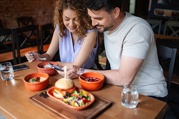 istock Couple enjoying lunch and looking at smartphone at restaurant 2234055969
