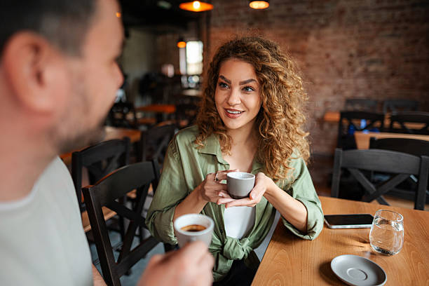 istock Young couple drinking coffee and talking at a cafe 2234055981