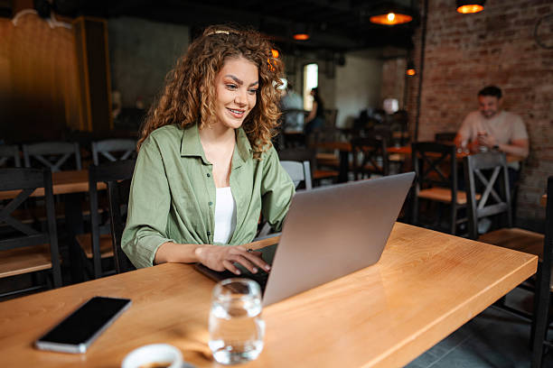 istock Young woman working on laptop in a cafe 2234056124