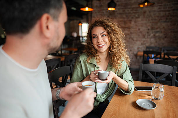istock Couple enjoying coffee and conversation in a cozy cafe 2234056269