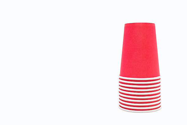 istock Red disposable cardboard cups stacked in a pile on a white background with free space for text 2234058838