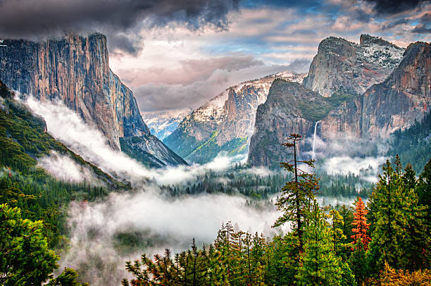 The iconic view from Tunnel View of Yosemite Valley, El Capitan, Bridalveil Falls, and Halfdome in the distance shot as a storm began to clear and fog started to form in the valley.