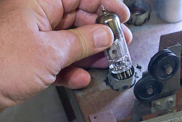 istock Hand holding a vacuum tube during a repair process on an electronic device in a workshop 2234068296