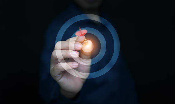 istock Hand throwing dart to glowing bullseye, representing success, precision, and leadership. Ideal for business strategy, motivation, achievement, and professional goal setting concepts. 2234070782