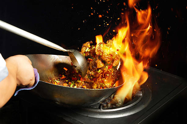 Skilled Chinese Chef Executing Traditional 'fire' Stir-Fry Technique,Professional Asian Chef Cooking Savory Dish in Wok