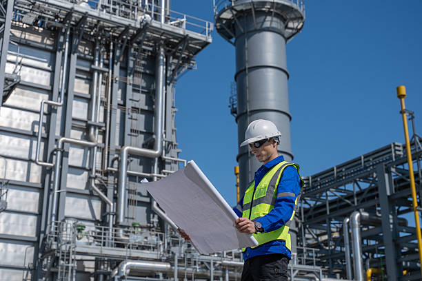 istock Engineer examines industrial architectural plans power plant facility tall structures, pipelines, and towers planning in construction, energy production, and heavy industry operations in a modern industrial environment. 2234076192