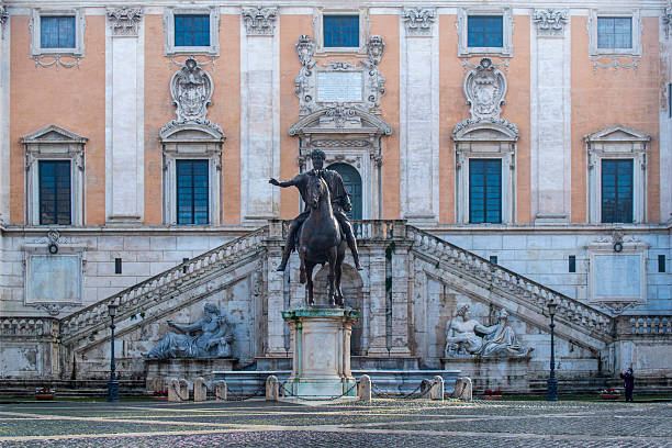 A view of the majestic equestrian statue of Emperor Marcus Aurelius, located in the center of Piazza del Campidoglio (the Roman Capitol Square) on the Capitoline Hill, designed by Michelangelo in 1534 in the heart of ancient Rome. The original statue of Marcus Aurelius is kept inside the Capitoline Museums, a few meters away. On the sides, placed at the top of the steps of the Capitoline Hill, the Roman monumental statues of Castor and Pollux, coming from the Circus Flaminio. In 1980 the historic center of Rome was declared a World Heritage Site by Unesco. Image in high definition format.