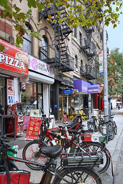 New York, NY - Aug. 28, 2025:  E-bikes used for delivery parked outside a pizza shop on 9th  Avenue in Hell's Kitchen district of Manhattan