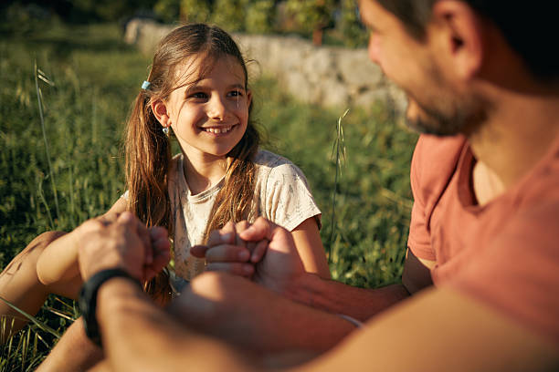 Beautiful father and daughter bonding, talking and enjoying nature on a sunset.