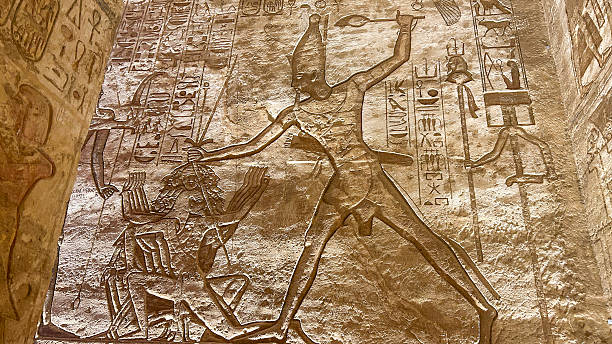 Abu Simbel, Egypt - Feb 8, 2025: Aswan, Egypt - Feb 7, 2025: Ancient relief at Abu Simbel showing Pharaoh smiting enemies with hieroglyphs.