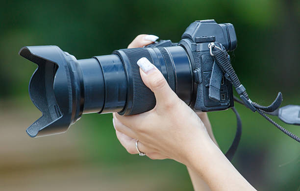 istock A person is holding a camera with a black lens 2234095919