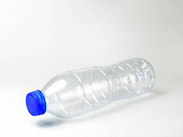 Empty transparent bottle with blue cap on light background symbolizing recycling efforts and waste reduction initiatives contributing towards a sustainable environment and circular economy