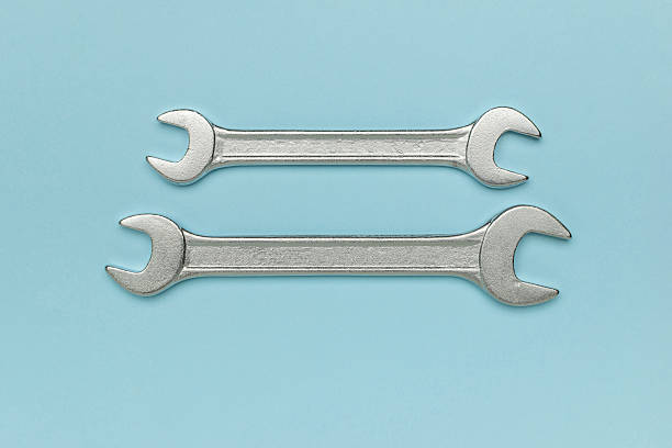 istock Minimalist Design of Two Metal Wrenches on Soft Blue Background 2234099320