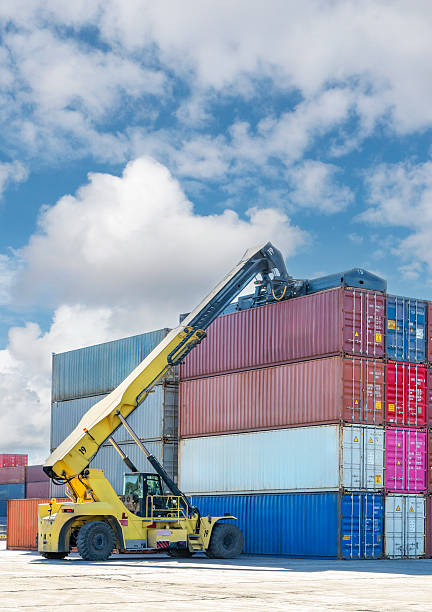 istock Crane lifting up container in yard. The loading truck is moving the freight container to the yard. 2234101826