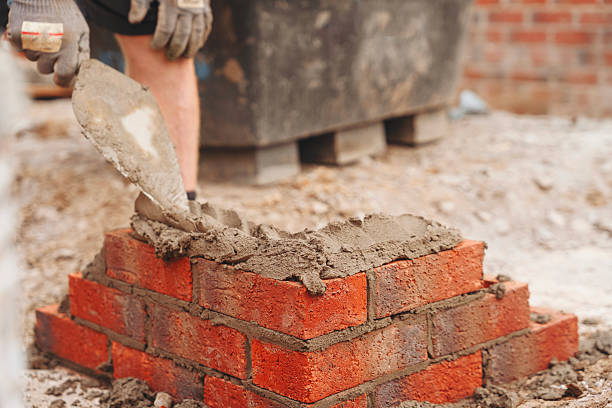 istock Construction worker laying bricks with a trowel in a building site during the day 2234102170