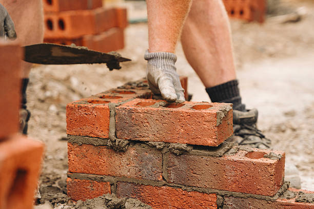 istock Stone masonry construction in progress with skilled worker laying bricks at a building site during daylight hours 2234102171