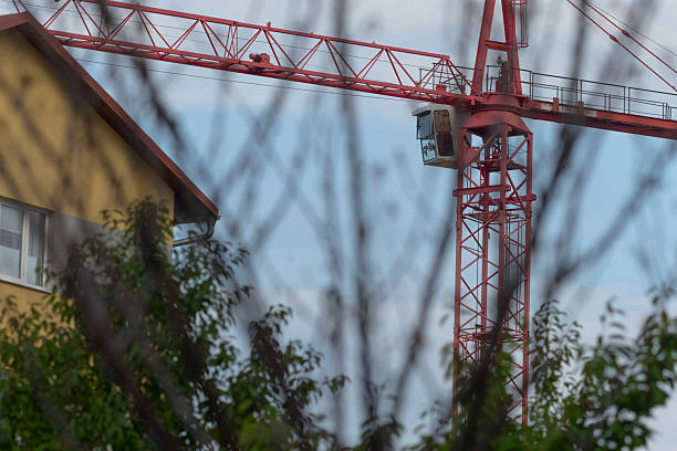 Red Construction Crane Overlooked by Residential Building