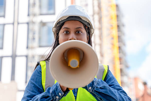 istock Construction worker directs team with megaphone at urban building site during daylight hours 2234104661