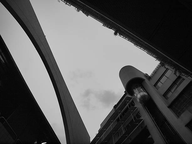 istock Cylindrical elevator of a building from outside view with some structure and sky in monotone. 2234104728