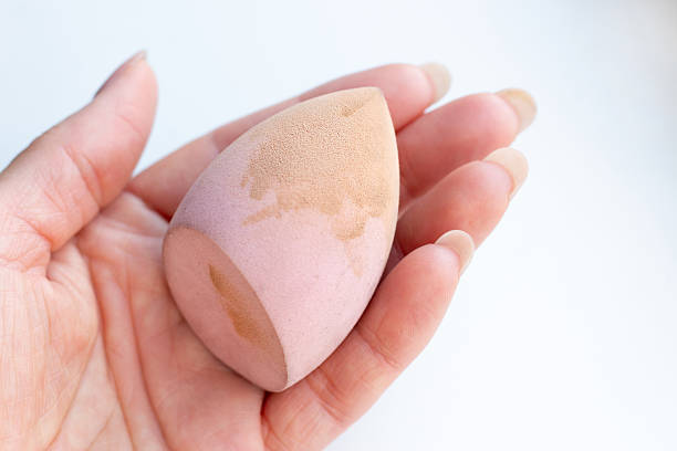 istock Woman's hand holding dirty cosmetic beauty sponge after using foundation. 2234105270