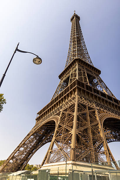 Eiffel tower against blue sky at morning. Photo made from pedestrian point of view. No people around