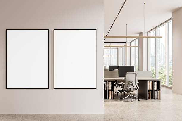 istock Two vertical blank poster mockups on a clean wall next to a bright modern office interior with desks and large windows overlooking a cityscape view. 3D Rendering 2234107811