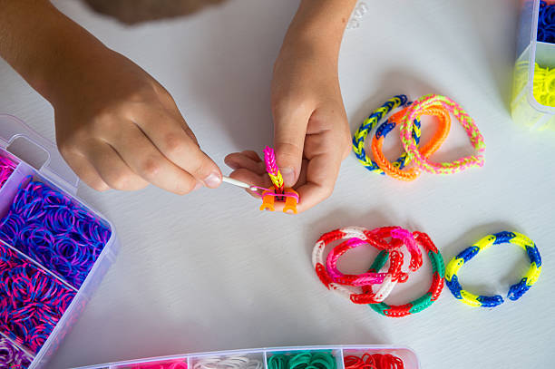 istock Colorful Loom Bracelets Being Crafted by Hand on White Background 2234110919