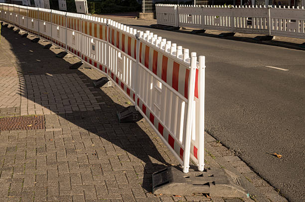 istock Red and white plastic road barriers separating sidewalk and street 2234112112